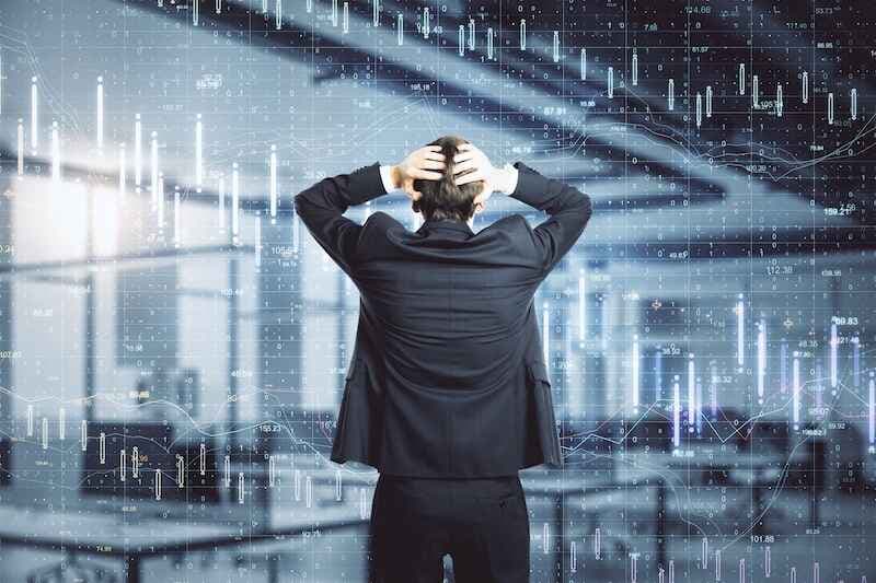 Scared businessman looking on creative crash recession chart hologram in office.