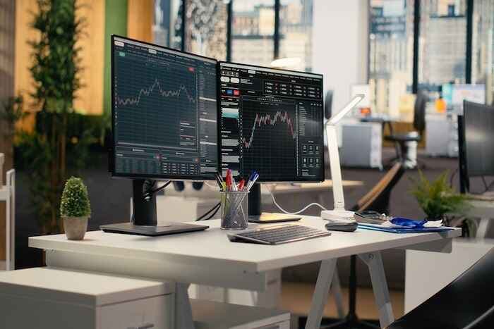 Trading platform on screens used by financial professionals tracking stock market activity using analytical tools. Brokerage company office with price graphs interface on computer displays