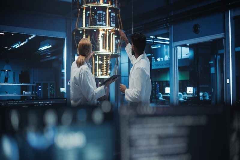 Female and Male Engineers Collaborating on Quantum Computer Development, Discussing a Report on a Tablet Computer in a Research Center. Colleagues Focusing on Innovation and Technology Breakthroughs